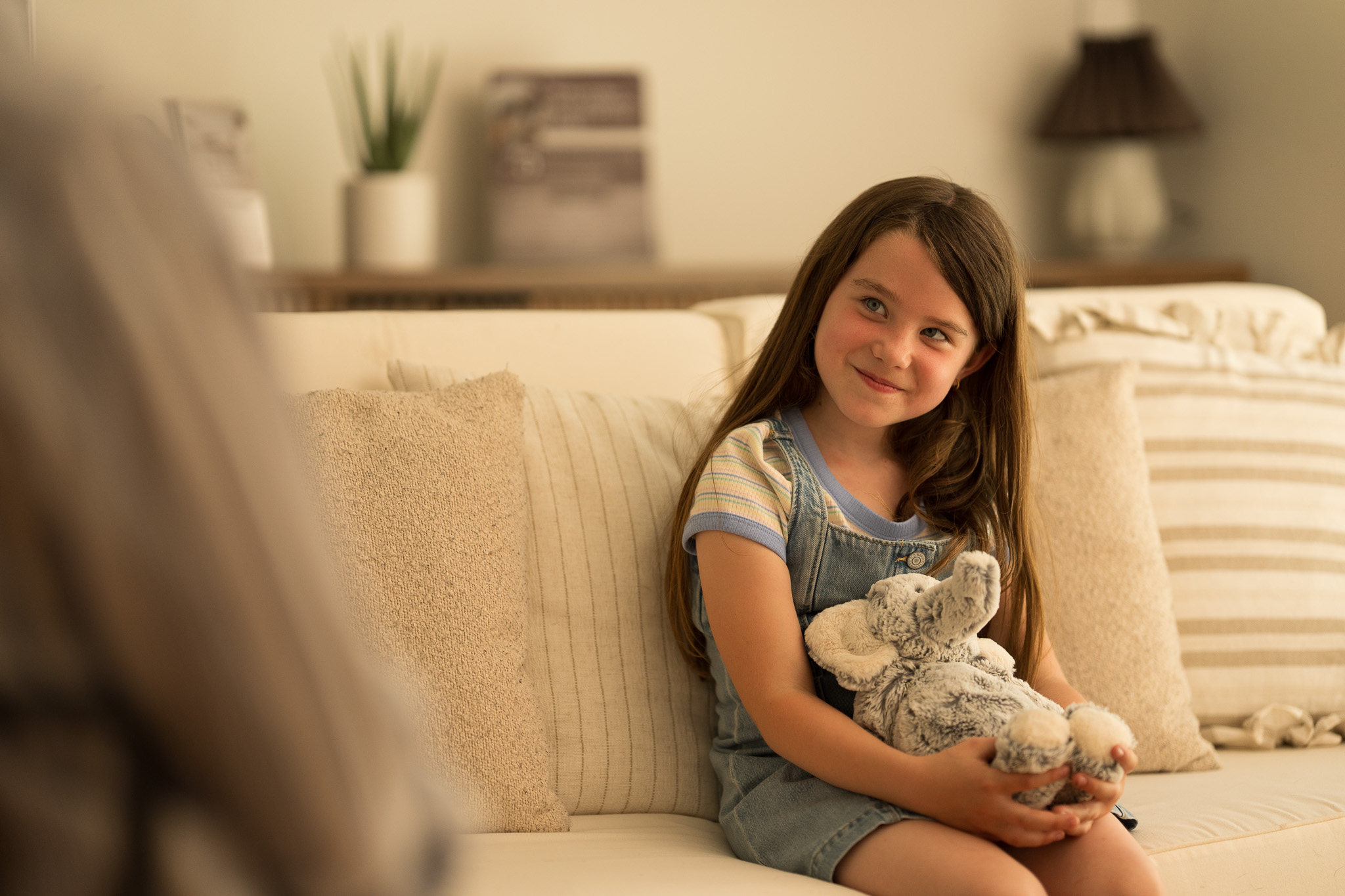 A smiling young girl holding a plush toy during a session